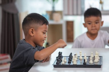 Genç bir çocuk yoğun bir konsantrasyonla satranç oynuyor..