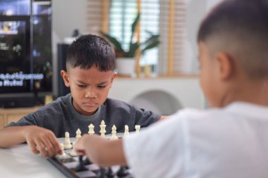 Genç bir çocuk yoğun bir konsantrasyonla satranç oynuyor..