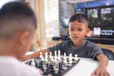 Genç bir çocuk yoğun bir konsantrasyonla satranç oynuyor..