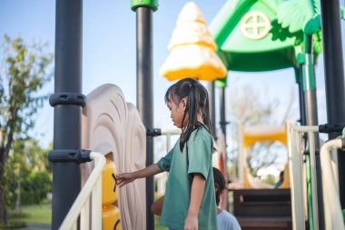 Genç bir kız parkta oynuyor.