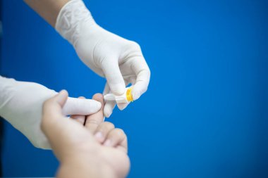 Bir insan kan alma ve küçük sarı bir nesnedir. Eldiven takıyor ve profesyonel bir doktor. Ayrıntılara dikkat ve özen kavramı