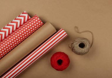 Paketleme ve paketleme hediyelerini kırmızı ve kahverengi kağıtlarla kapayın, masa üstü görünümü, düz yatış