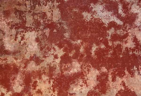 Grunge red and brown old painted concrete or stone wall background texture with stains of faded paint peel and scaling, uneven and weathered