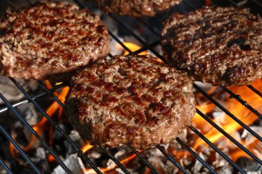 Biftek ya da domuz eti barbeküsü hamburgerleri BBC alev ızgarasında kızartılmış, yüksek açı manzaralı.