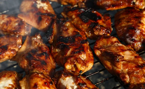 バーベキューチャーグリルで鶏の水牛や照り焼きソースの翼を調理し 喫煙を閉じる 高角度ビュー — ストック写真
