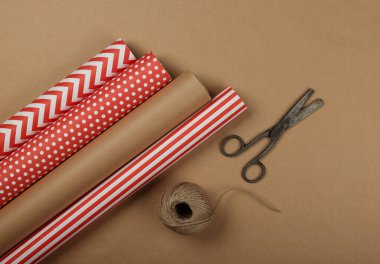 Paketleme ve paketleme hediyelerini kırmızı ve kahverengi kağıtlarla kapayın, masa üstü görünümü, düz yatış