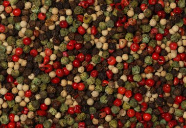 Karmaşık biberlerin arka planı, siyah, yeşil, beyaz ve pembe, doğal baharat deseni dokusu, yüksek üst görünüm, tam üstte.