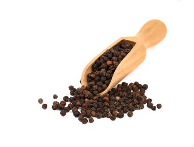 Bir kepçe karabiber ve biber dolu ahşap kepçeyi kapatın ve beyaz arka planda izole edilmiş ve yayılmış bir yığın biber, yüksek açılı görüş