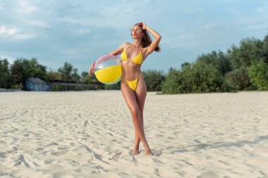 Genç bir kadın sahilde dinleniyor.