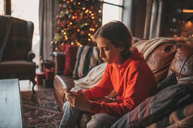 Uzun saçlı, düşünceli üzgün bakışlı, sinirli ve evde ağlayan genç bir çocuk. Şık bir zoomer olan Z jenerasyonu, yeni yıl tatilinde Noel ağacı ışıklarıyla süslenmiş 25 Aralık arifesi.