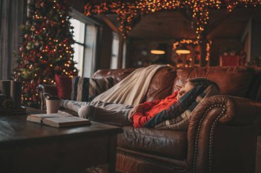 Uzun saçlı, düşünceli üzgün bakışlı, sinirli ve evde ağlayan genç bir çocuk. Şık bir zoomer olan Z jenerasyonu, yeni yıl tatilinde Noel ağacı ışıklarıyla süslenmiş 25 Aralık arifesi.