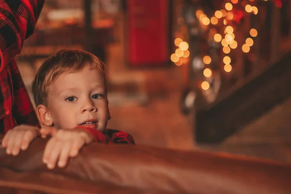 動く楽しさと奇跡のサンタを待っている笑顔の小さな子供がアクティブになっています 赤いチェッカースリーブ子供遊び楽しい室内ジャンプ移動笑うガーランドライトノエルツリーEve 12月 — ストック写真