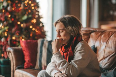 Genç, duygusal, neşeli, uzun saçlı, kahkahalar atan ve rahat evinde neşeli bir çocuk. Zoomer Z jeneratörünün keyfi yerinde. 25 Aralık arifesi Noel arifesi Noel ağacıyla Noel tatili kutlanıyor.