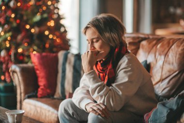 Genç, duygusal, neşeli, uzun saçlı, kahkahalar atan ve rahat evinde neşeli bir çocuk. Zoomer Z jeneratörünün keyfi yerinde. 25 Aralık arifesi Noel arifesi Noel ağacıyla Noel tatili kutlanıyor.
