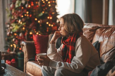 Genç, duygusal, neşeli, uzun saçlı, kahkahalar atan ve rahat evinde neşeli bir çocuk. Zoomer Z jeneratörünün keyfi yerinde. 25 Aralık arifesi Noel arifesi Noel ağacıyla Noel tatili kutlanıyor.