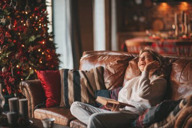Genç, duygusal, neşeli, uzun saçlı, kahkahalar atan ve rahat evinde neşeli bir çocuk. Zoomer Z jeneratörünün keyfi yerinde. 25 Aralık arifesi Noel arifesi Noel ağacıyla Noel tatili kutlanıyor.