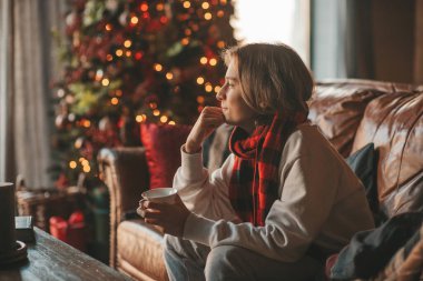 Genç, duygusal, neşeli, uzun saçlı, kahkahalar atan ve rahat evinde neşeli bir çocuk. Zoomer Z jeneratörünün keyfi yerinde. 25 Aralık arifesi Noel arifesi Noel ağacıyla Noel tatili kutlanıyor.