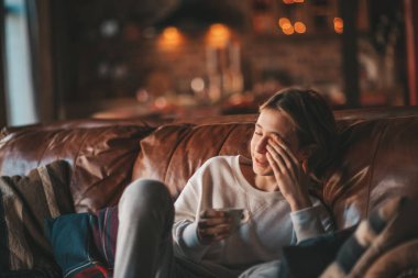 Genç, duygusal, neşeli, uzun saçlı, kahkahalar atan ve rahat evinde neşeli bir çocuk. Zoomer Z jeneratörünün keyfi yerinde. 25 Aralık arifesi Noel arifesi Noel ağacıyla Noel tatili kutlanıyor.