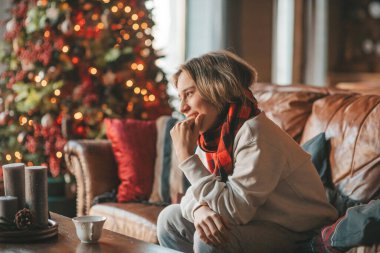 Genç, duygusal, neşeli, uzun saçlı, kahkahalar atan ve rahat evinde neşeli bir çocuk. Zoomer Z jeneratörünün keyfi yerinde. 25 Aralık arifesi Noel arifesi Noel ağacıyla Noel tatili kutlanıyor.