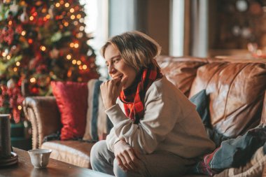 Genç, duygusal, neşeli, uzun saçlı, kahkahalar atan ve rahat evinde neşeli bir çocuk. Zoomer Z jeneratörünün keyfi yerinde. 25 Aralık arifesi Noel arifesi Noel ağacıyla Noel tatili kutlanıyor.