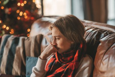 Uzun saçlı, düşünceli üzgün bakışlı, sinirli ve evde ağlayan genç bir çocuk. Şık bir zoomer olan Z jenerasyonu, yeni yıl tatilinde Noel ağacı ışıklarıyla süslenmiş 25 Aralık arifesi.