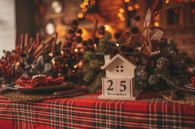 25 Aralık 'taki mutlu noeller. Peri masalı heyecanı. Işıldayan bokeh çelenk parlak pırıltılı ışıklar Noel ağacı süslemeleri tahta küp takvim şenlik mumları kış tatili ruhu Xmas