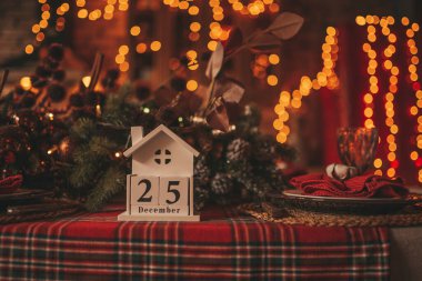 25 Aralık 'taki mutlu noeller. Peri masalı heyecanı. Işıldayan bokeh çelenk parlak pırıltılı ışıklar Noel ağacı süslemeleri tahta küp takvim şenlik mumları kış tatili ruhu Xmas