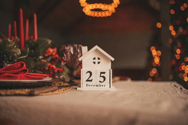 25 Aralık 'taki mutlu noeller. Peri masalı heyecanı. Işıldayan bokeh çelenk parlak pırıltılı ışıklar Noel ağacı süslemeleri tahta küp takvim şenlik mumları kış tatili ruhu Xmas