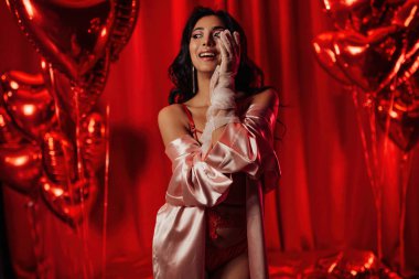 Japanese woman wearing sexy lace underwear posing on red glamour background 