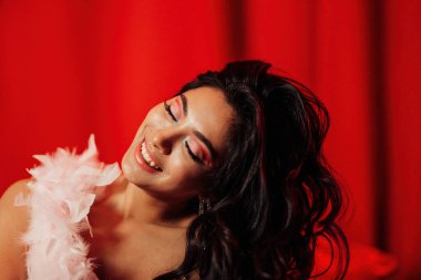 Close up portrait of sexy brunette asian woman with perfect skin posing on red background 