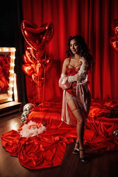 Young japanese woman wearing sexy lace underwear posing in full growth on red glamour background 