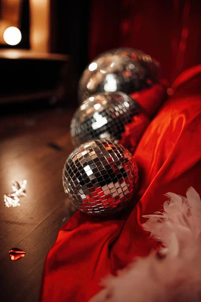 Glossy mirror balls in extravagant atmosphere interior decoration at vivid red background glamour. Beautiful place for saint valentines holiday with disco balls in romantic burlesque bedroom