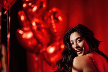 Close up portrait of attractive asian woman with perfect skin posing in a red room