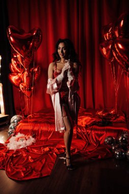 Attractive japanese woman wearing sexy lace underwear posing in full growth on red glamour background 