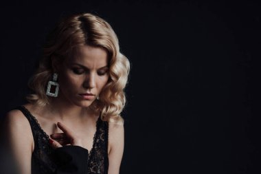 Young adult beauty woman in formal evening suit of black color with lace bra at thoughtful. Stylish blonde curly hair sensual model fashionista posing at studio in fashion pantsuit