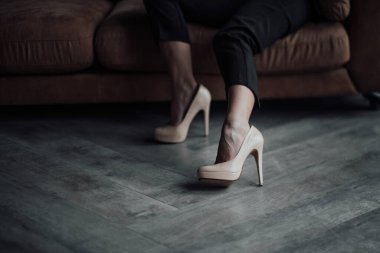 Young adult beauty woman in formal evening suit of black color with lace bra at thoughtful. Stylish blonde curly hair sensual model fashionista posing at studio in fashion pantsuit