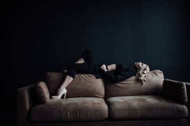 Young adult beauty woman in formal evening suit of black color with lace bra at thoughtful. Stylish blonde curly hair sensual model fashionista posing at studio in fashion pantsuit