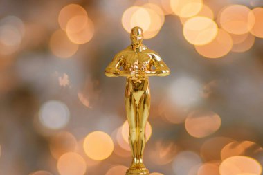 Hollywood altın Oscar ödüllü biblo taklidi bir ödül töreni sırasında görüldü. Başarı ve zafer konsepti parlak sarı ışıklar arka planında heykelciği kapatın