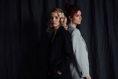 Yetişkin, zarif, çok ırklı genç kızlar resmi gece kıyafetleriyle farklı renklerde sutyenle. Şık sarışın ve kızıl saçlı moda modacıları. Moda kıyafetleriyle stüdyoda poz veriyorlar. Gömlek yok.