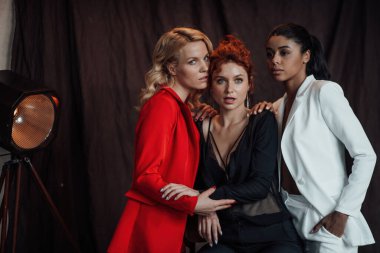 Yetişkin, zarif, çok ırklı genç kızlar resmi gece kıyafetleri ve farklı renkte sutyenleri var. Moda kıyafetleriyle stüdyoda poz veren şık, değişik insanlar. Gömlek yok.