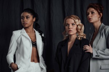 Yetişkin, zarif, çok ırklı genç kızlar resmi gece kıyafetleri ve farklı renkte sutyenleri var. Moda kıyafetleriyle stüdyoda poz veren şık, değişik insanlar. Gömlek yok.