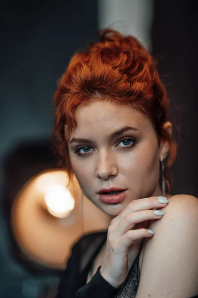 stock image Adult beauty elegant young woman in formal evening black clothing hand on face touching. Stylish ginger curly hair sensual model bare shoulder fashionista posing at studio in fashion pantsuit and bra