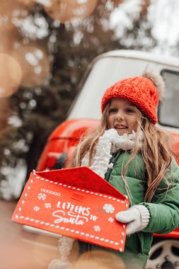 Noel 'i ve yeni yılı kutlayan bayan çocuk kış tatilini dışarıda kutluyor. Küçük kız açık havada Noel Baba 'ya kırmızı zarfla mektup yazıp mucize bekliyor.