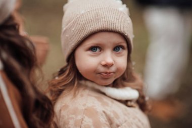 Noel 'i ve yeni yılı kutlayan bayan çocuk kış tatilini dışarıda kutluyor. Aktif küçük kız kozalaklı ormanda çocukluğunun tadını çıkarıyor.