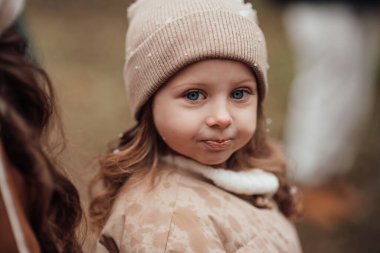 Noel 'i ve yeni yılı kutlayan bayan çocuk kış tatilini dışarıda kutluyor. Aktif küçük kız kozalaklı ormanda çocukluğunun tadını çıkarıyor.