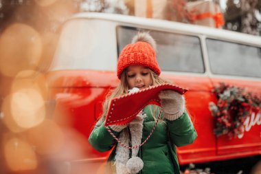 Noel 'i ve yeni yılı kutlayan bayan çocuk kış tatilini dışarıda kutluyor. Küçük kız açık havada Noel Baba 'ya kırmızı zarfla mektup yazıp mucize bekliyor.