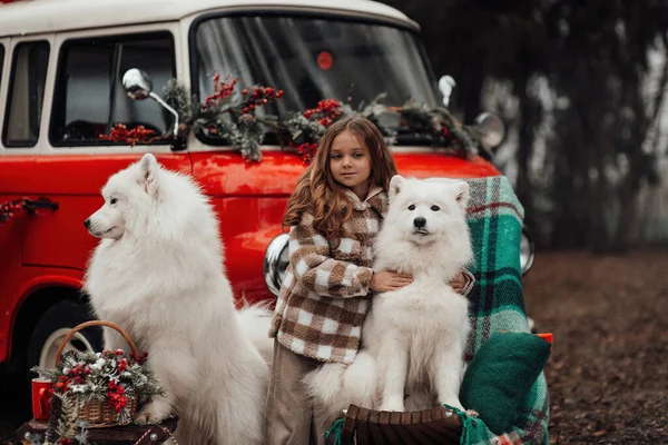 クリスマスと新年の冬休みシーズンの屋外を祝う女性の子供 子供の頃を楽しんでいるXmasバス近くの白いサモイド犬とオープンエアで楽しい時間を過ごす小さな少女 — ストック写真