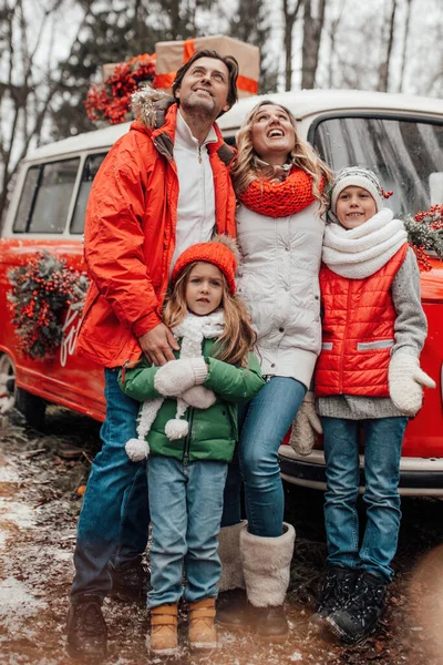 クリスマスと新年の冬の休暇シーズンの屋外を祝う幸せな家族 親と一緒に楽しい時間を過ごすアクティブな子供たちは 最初の雪でXmasバスリージョイスの近くで楽しんで抱擁します — ストック写真