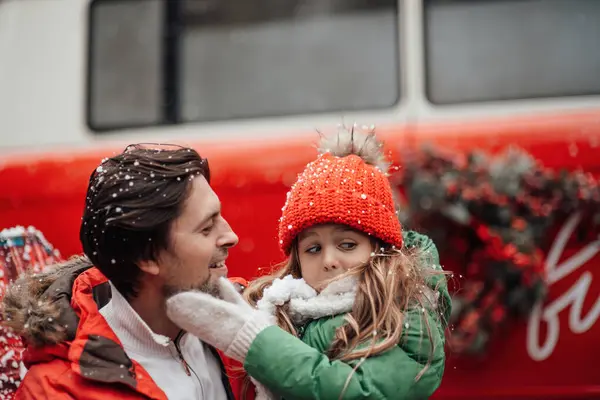 クリスマスと新年の冬の休暇シーズンの屋外を祝う幸せな家族 小さな娘と一緒に楽しい時間を過ごす父親は 最初の雪でXmasバスリージョイスの近くで楽しんで抱擁 — ストック写真
