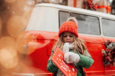 Noel 'i ve yeni yılı kutlayan bayan çocuk kış tatilini dışarıda kutluyor. Küçük kız açık havada Noel Baba 'ya kırmızı zarfla mektup yazıp mucize bekliyor.